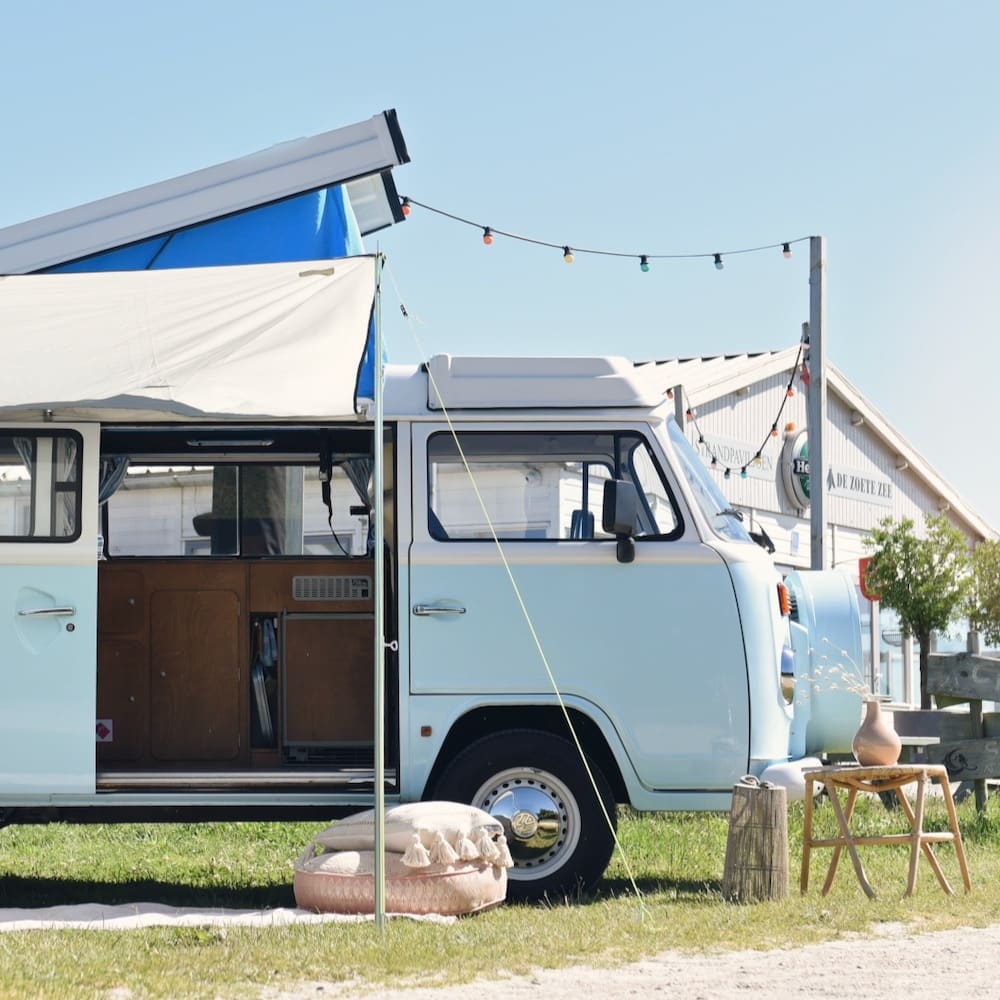 Volkswagen camper met dak omhoog en een luifel